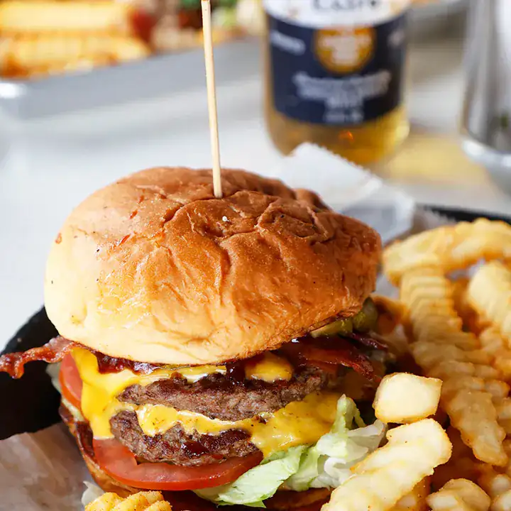 Lulu's bacon cheeseburger served with crinkle-cut fries.